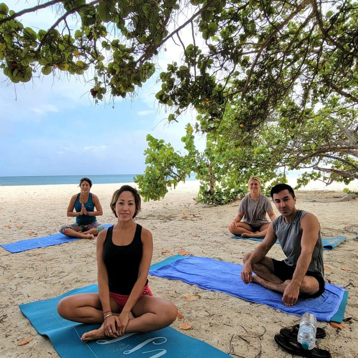 Guests sitting together on their mats smiling after the class