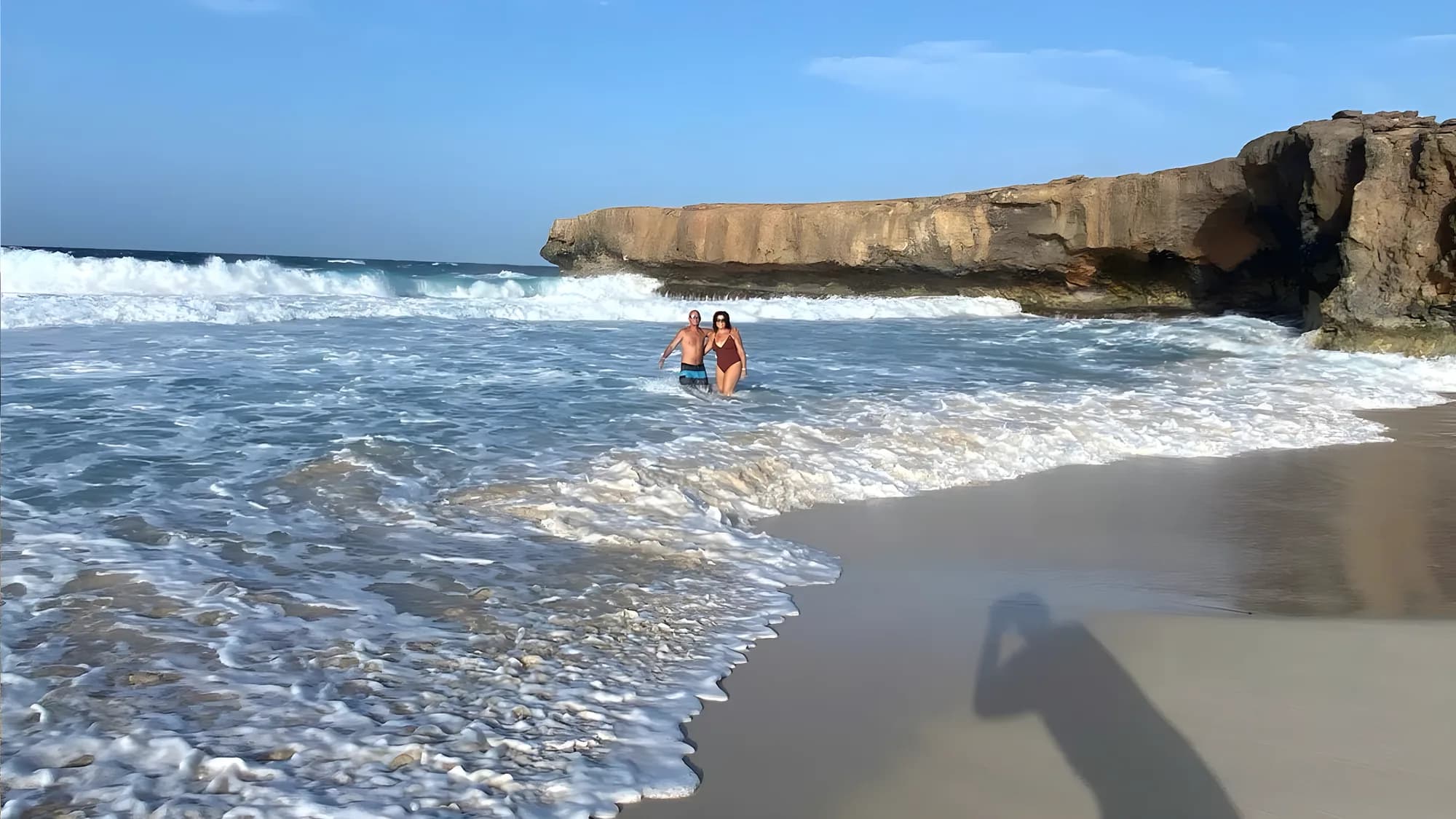 Waves rolling onto the sand under the cliff at Dos Playa