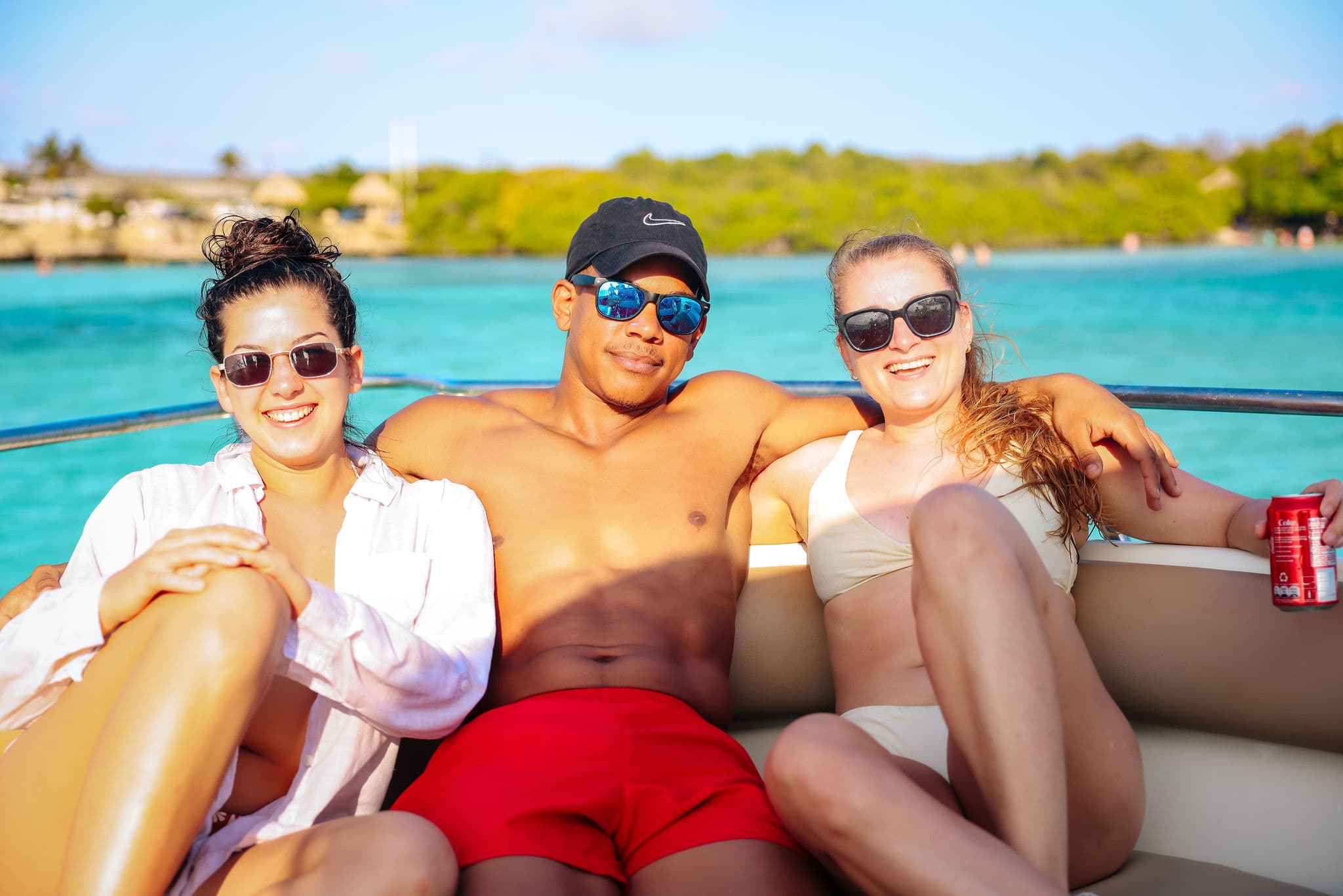 Friends relaxing together on the bow of a private boat charter in Aruba