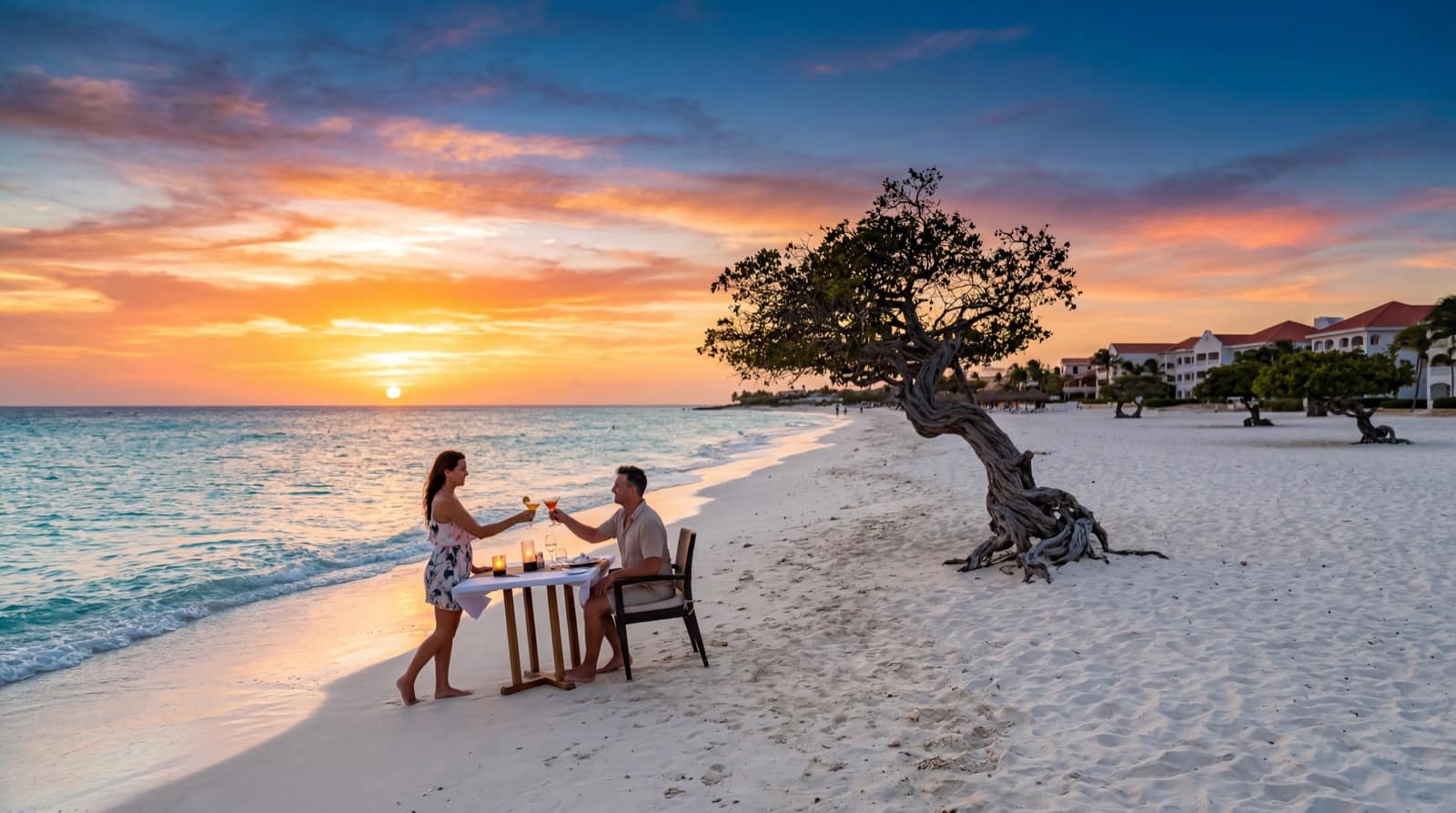 A couple sharing a toast at golden hour on Eagle Beach, Aruba