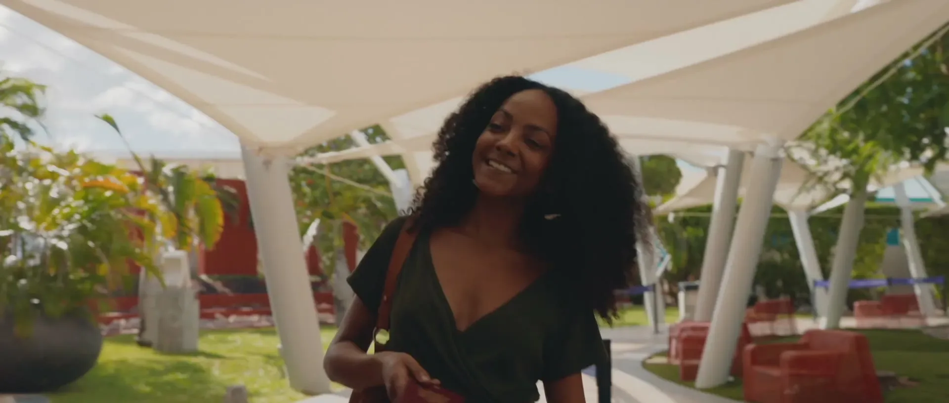 A traveller walking through the shaded arrival courtyard at Aruba’s airport
