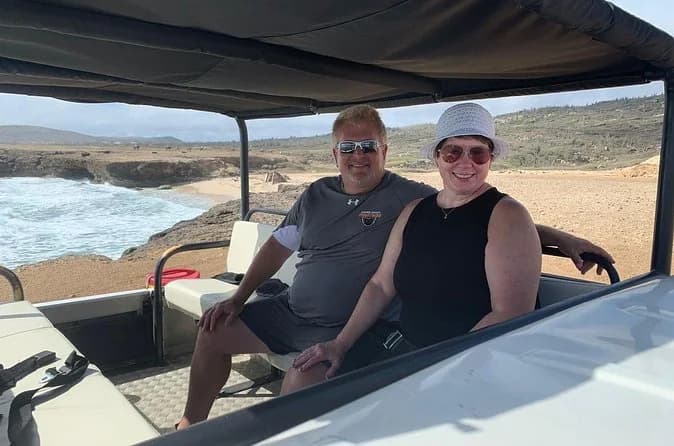 Guests seated in the open rear of the private Jeep safari operator’s vehicle on Aruba’s coast